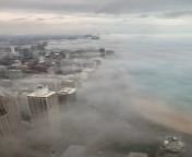 A formation of low clouds by the lakefront in Chicago, Illinois, surrounded the buildings. The sheets of vapor engulfed the tall structures while the city moved in its daily hustle.